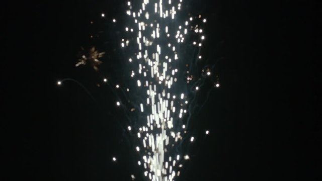 Sparkling fountain fireworks filmed in slow motion with soft focus to create a pleasing pattern of moving bokeh.