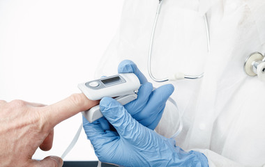 Doctor using pulse oximeter to check oxygen saturation of a person tracking coronavirus symptoms
