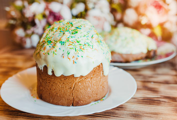 Beautiful icing easter cakes decorated with colored powder on wooden background with flowers. Happy Easter Holidays.