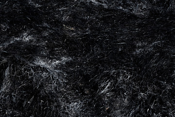 Black surface of the rural field with a burned grass. Effects of grass fire on soils. Charred grass after a spring fire. Consequences of arson and stubble burning. Aftermath of Natural Disasters.