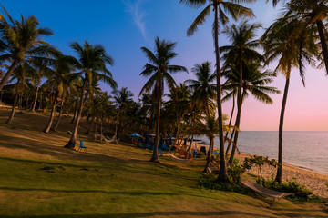 Fototapeta na wymiar Beautiful beach with palms at sunset in Phu Quoc, Vietnam