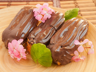 Eclair with chocolate custard decorated with pink flowers