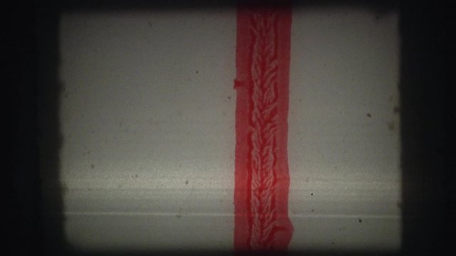 Film Tape from Super 8mm home movie, wound, with smudges, grains and other manual editing patterns on moviola