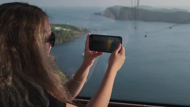 Woman capturing sea scenery from cable car in Phu Quoc, Vietnam