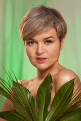Naklejka premium Beauty woman with natural green palm leaf portrait, model girl with perfect makeup