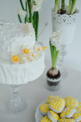 white cake hyacinths and yellow daffodils on the table