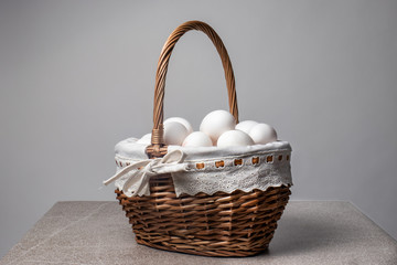 Fototapeta na wymiar Beautiful wicker basket with chicken white eggs.