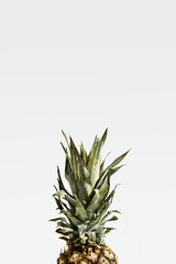 Fototapeta premium Ripe juicy pineapple fruit with green leaves isolated on white.