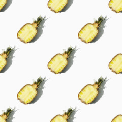 Beautiful bright pattern of halves of ripe juicy pineapple on a white background.