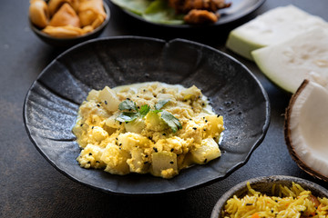 Oriental food - traditional Indian vegetarian dish of Bottle Gourd vegetable or Doodhi called Lauki Sabji. indian cuisine. Indian coconut Curry with ingredients in black background close-up, top view.