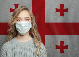 Young woman wearing a face mask with national Georgian  flag. Flu epidemic and virus protection...