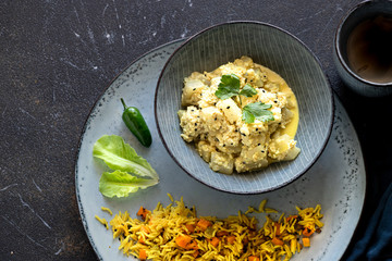 Oriental food - traditional Indian vegetarian dish of Bottle Gourd vegetable or Doodhi called Lauki Sabji. indian cuisine. Indian coconut Curry with ingredients in black background close-up, top view.