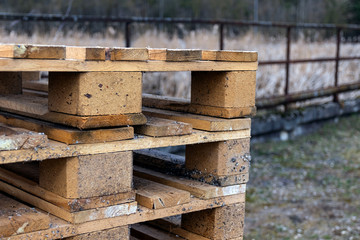 Wooden production pallets stand piled in a pile. Close-up.