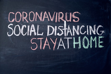 inscription stay at home. Outbreak Warning. written white chalk on blackboard in connection with epidemic of coronavirus worldwide.