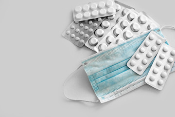 Medicines: tablets in transparent sticks, in metal non-trasparent sticks and ampuls with anti-virus vaccine and medical anti-virus protection face mask on white background.