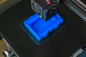 Fototapeta na wymiar The 3D printer prints blue plastic model