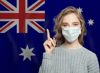 Woman in medical mask pointing up against national flag australia background. Flu epidemic and...