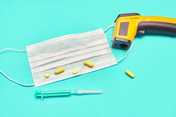 medical protective mask yellow pills syringe on a blue background