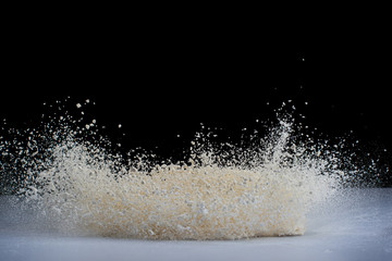 explosion of flour and components, lifting them into the air on a white surface on a black background