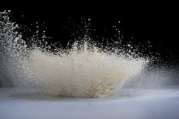 explosion of flour and components, lifting them into the air on a white surface on a black background