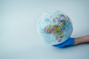 doctor with a world globe wrapped in plastic