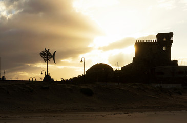  Sunrise in Tarifa. Tuna shaped wind vane and ancient  Santa Catalina castle. Tarifa is the...