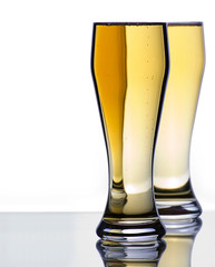 Two Ice Cold Beer Glasses on Reflective Surface with Copy Space