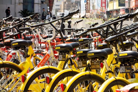 Bike sharing in Shanghai city with yellow Ofo bicycles focused Mobike in the background