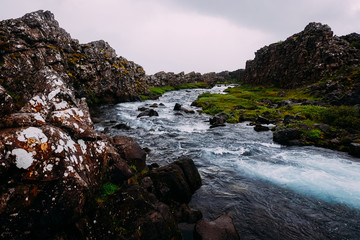 mountain river among cliffs with clear water in the summer national park of Iceland