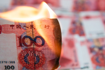 Burning Chinese yuan as symbol economic recession.