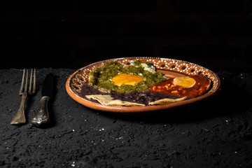 Mexican breakfast divorced eggs with black background