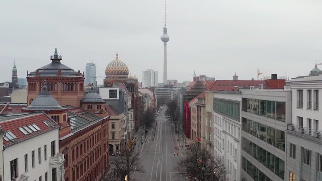 AERIAL: Slow flight trough Empty Central Berlin Neighbourhood Street with Cathedrals and view on Alexanderplatz TV Tower during Corona Virus COVID19 on Overcast Cloudy Day