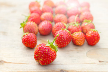 Natural organic food production. Freshly picked juicy strawberries on wooden background. Heap of summer red berries. Homegrown, gardening and agriculture consept.