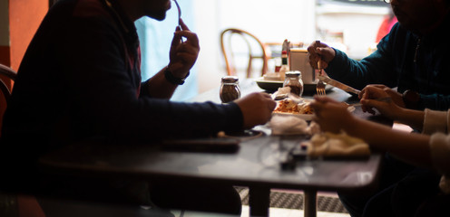 Silhouette of a group of young friends having lunch in a restaurant in a festive day. Indian lifestyle.