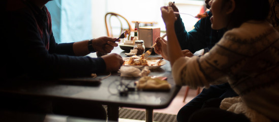 Silhouette of a group of young friends having lunch in a restaurant in a festive day. Indian lifestyle.
