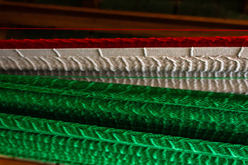 Obraz premium Closeup on handmade hammock with Mexican Flag colors. Colorful rich texture, these homemade nets are comfortable for a relaxing siesta. Hammocks or hamacas are used by Mayan descendants to sleep in.