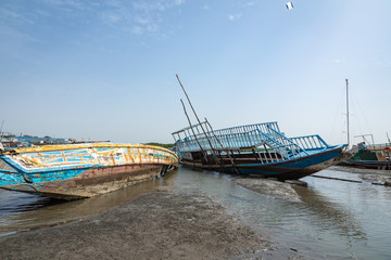 Old and abandoned ships anchored in Banjul Bay, at low tide.