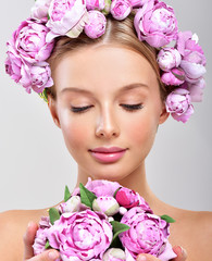 Fashion Beauty Model Girl with flowers in the hair. Bouquet of Beautiful Flowers. Perfect skin