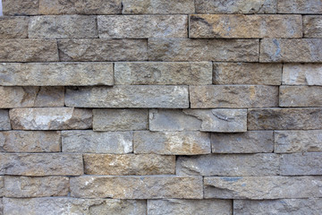 wall of natural stone blocks of gray and sand color