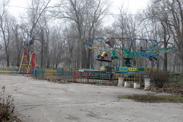 Fototapeta na wymiar an old soviet carousel in the autumn park on a cloudy day