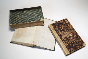 Composition of old books, with yellowed and ruined pages. Light background.