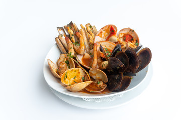 Sauteed shellfish and seafood in a white plate on a white background