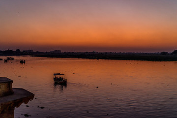 Naklejka premium Boats on river in India during sunset