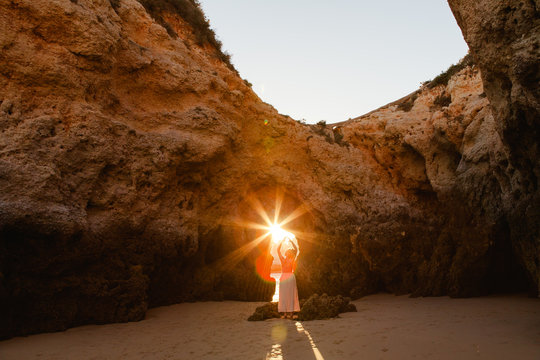 Woman holding a sunburst in the beach coves of Algarve, Portugal