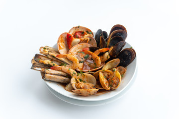 Sauteed shellfish and seafood in a white plate on a white background