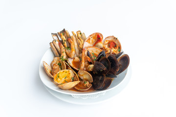 Sauteed shellfish and seafood in a white plate on a white background