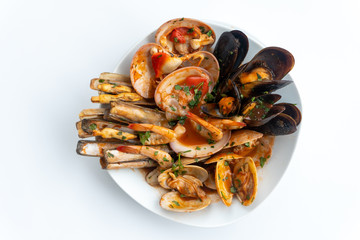 Sauteed shellfish and seafood in a white plate on a white background