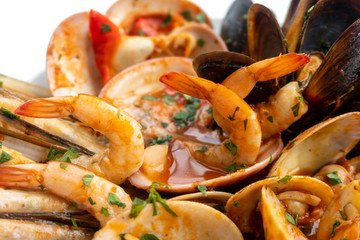 Sauteed shellfish and seafood in a white plate on a white background