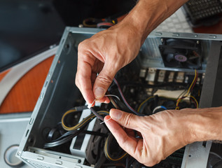 Hands of a man repairing a computer.