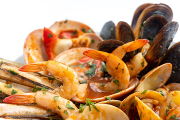 Sauteed shellfish and seafood in a white plate on a white background